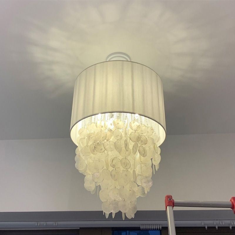 Lámpara colgante contemporánea con forma de concha de medusa y pantalla cilíndrica.